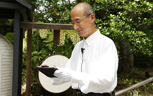 陣屋様のスタッフさんのお写真(1):タブレットでお客様情報を確認して、お迎えの準備をしている